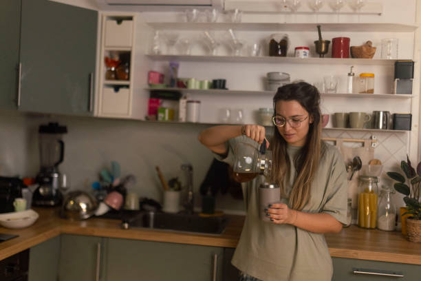 istock A woman pours tea from a kettle into reusable gray cup 1860227659