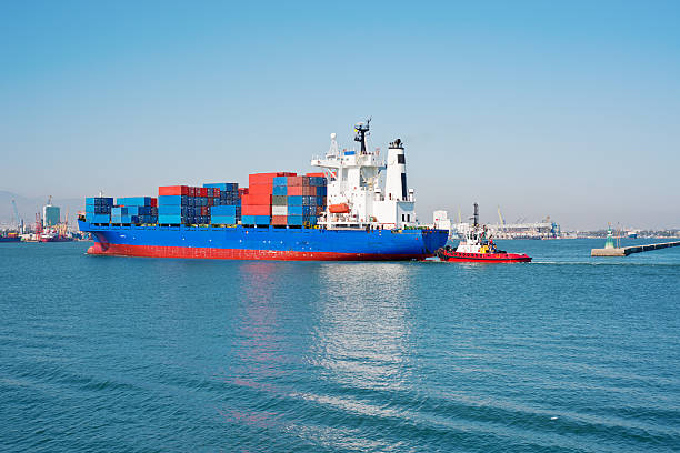 istock Freighter being guided into port by tug. 186022863