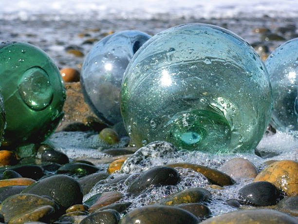 Glass Fishing Floats on a cobble stone beach with sea foam