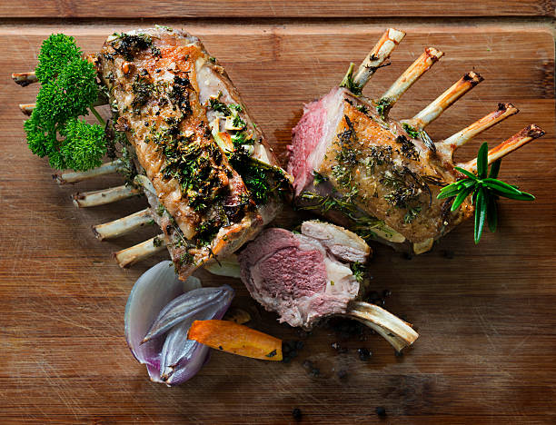 Roasted rack of lamb with parsley sage rosemary and thyme Home made roasted rack of lamb with herbs, salt and pepper in perfect pink colour. rack of lamb stock pictures, royalty-free photos & images