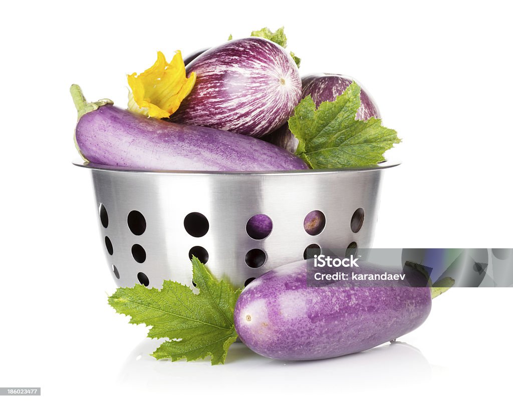 Fresh ripe eggplants in colander Fresh ripe eggplants in colander. Isolated on white background Bowl Stock Photo