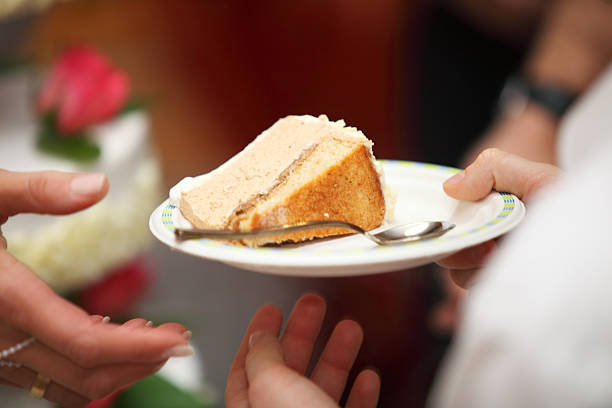 istock slice of the wedding cake in hand 186025173