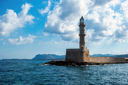 Crete island, Greece. Lighthouse, beacon at Venetian harbour in Old Town of Chania, blue sky, sunny day.