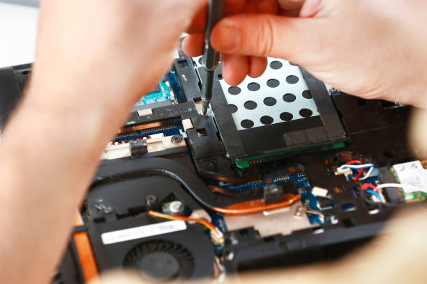 istock Repaiman with screwdriver fixing disassembled laptop parts. Technical support and fixing gadgets problems. Servicing, repairing, cleaning, maintaining computers. Repair shop. Hardware maintenanc 1860268027