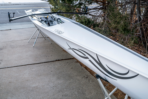 Fort Collins, CO, USA - December 2, 2023: Coastal rowing shell, Literace 1x by Litebox, on stands in a driveway. This boat, made in France, is designed for competition, combining speed and stability.