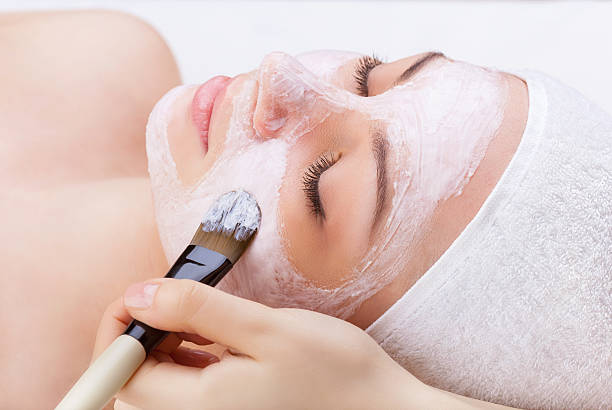 istock Woman's face with paintbrush with cream 186028421