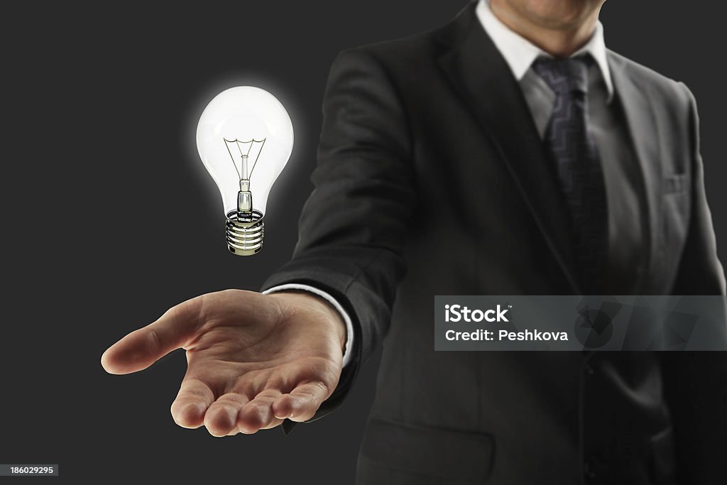 man holding lightbulb man holding lightbulb in hand Adult Stock Photo