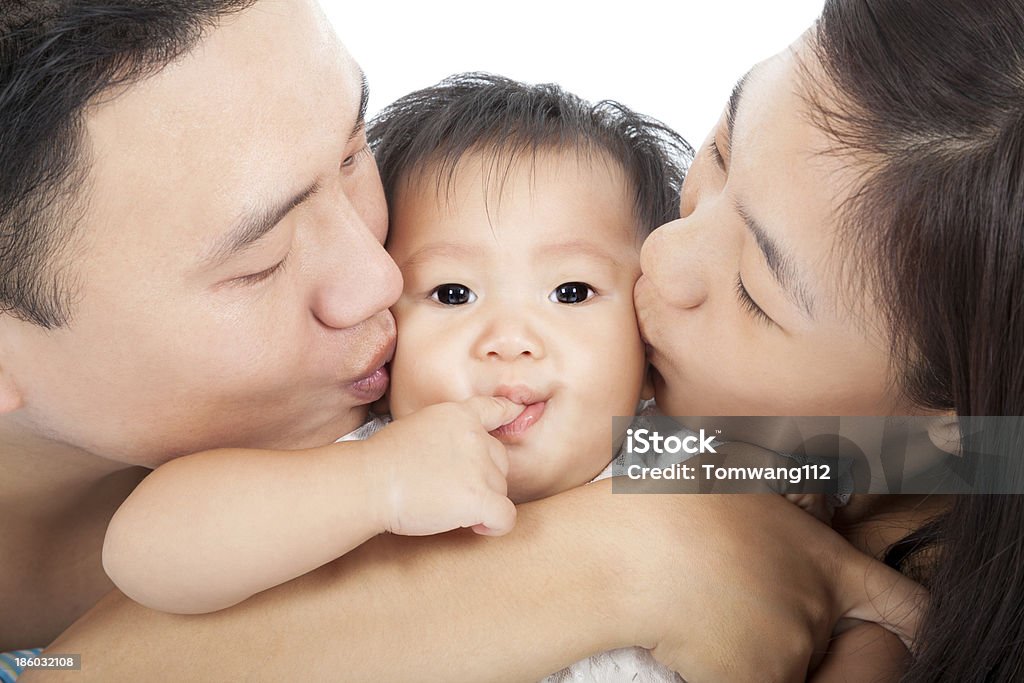 FAMIGLIA FELICE Baciare il bambino - Foto stock royalty-free di Accudire