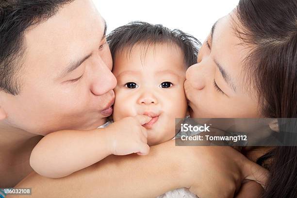 Famiglia Felice Baciare Il Bambino - Fotografie stock e altre immagini di Accudire - Accudire, Adulto, Allegro