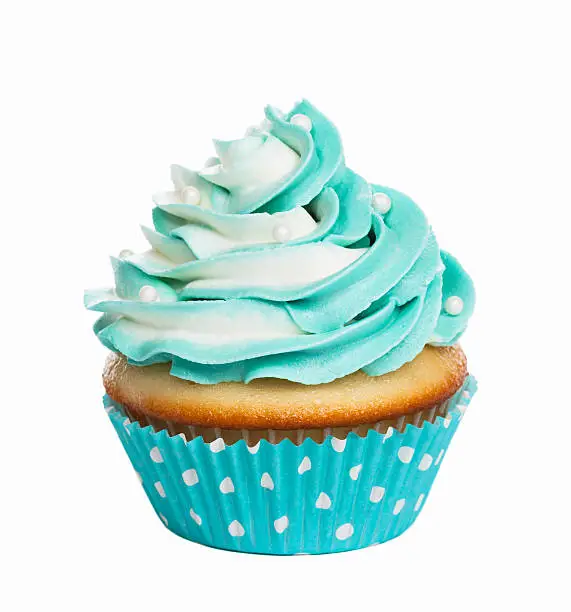 Teal birthday cupcake with butter cream icing isolated on white.