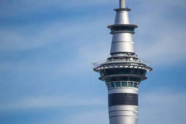Close-up of Auckland's Sky Tower on a beautiful sunny day, blue sky with puffy clouds.