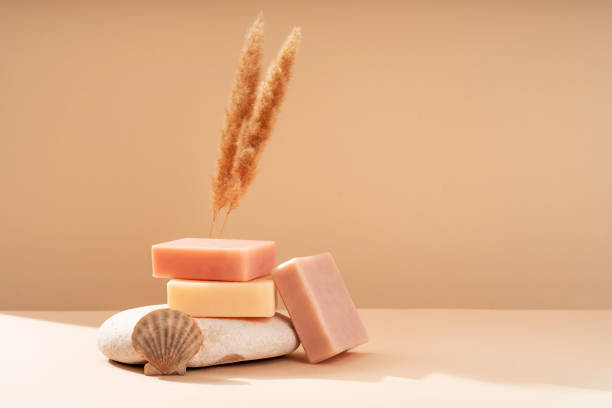 istock Pattern natural handmade soap of different sizes and colors. Peach background shadows of flowers from the sun. Cosmetic pedestal for product promotion. 1860364932