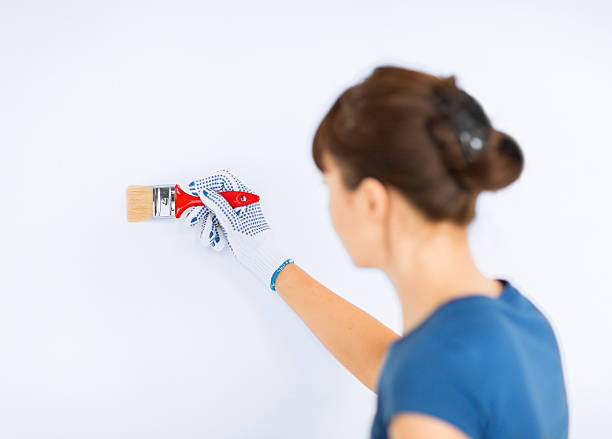 istock woman with paintbrush colouring the wall 186040843