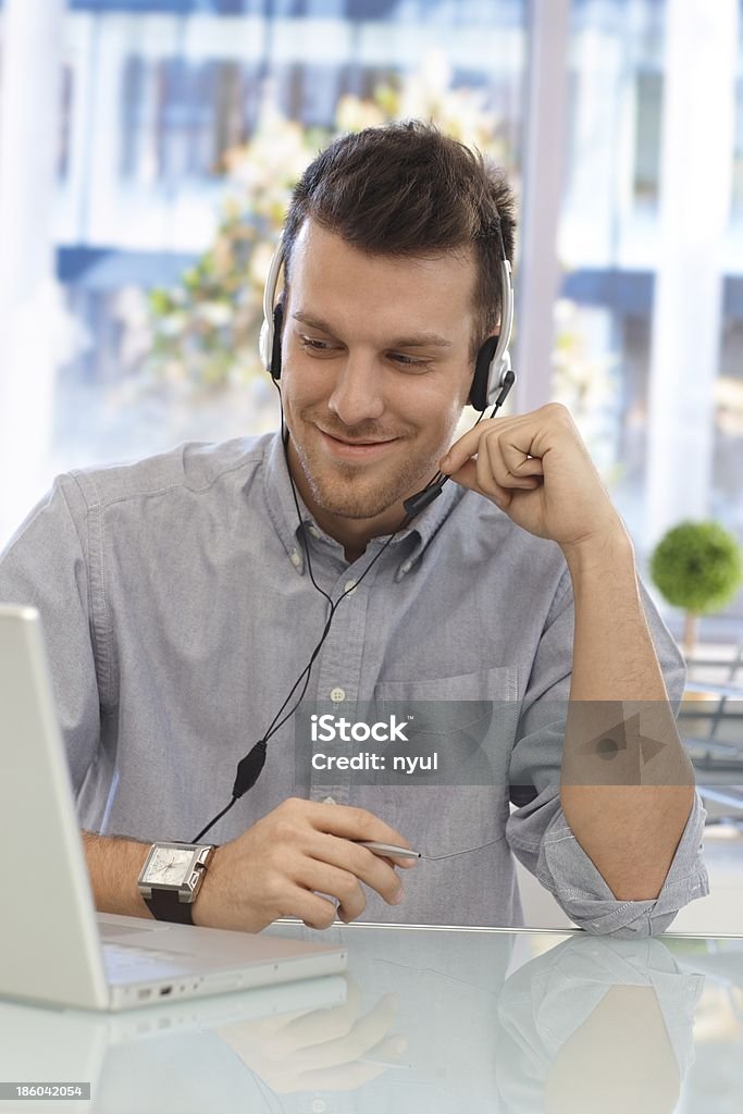 Homem feliz trabalhando no callcenter - Foto de stock de Fone de Ouvido - Equipamento de informação royalty-free