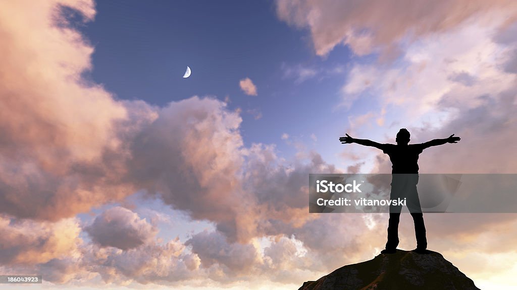 freedom man' s silhouette with her hands raised in the sunset Adult Stock Photo