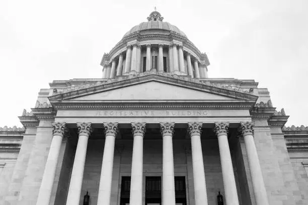 Grainy archival black and white film photograph of the Washington State Capitol Building with cloudy sky.  Shot May 1992.