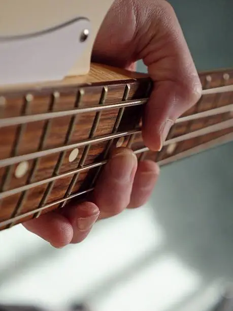 Fingers on fretboard of guitar.
