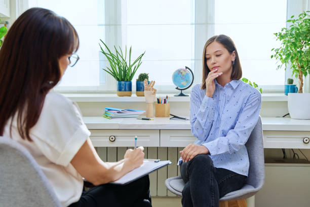 istock Sad stressed young woman in therapy with psychologist 1860471638