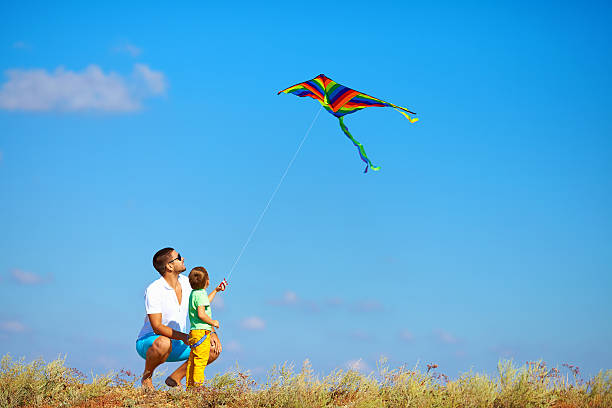 istock father and son having fun, playing with kite together 186048692