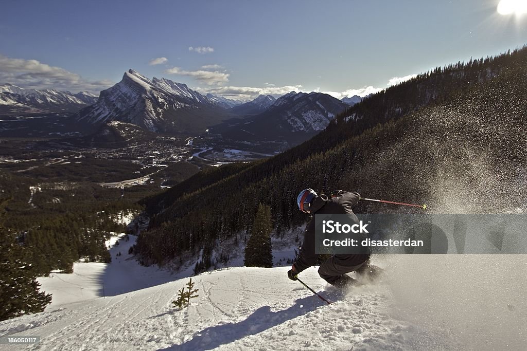 Skiing in Banff Male Skier enjoys fresh powder in Banff National Park, with the Town of Banff visible in background. Banff Stock Photo