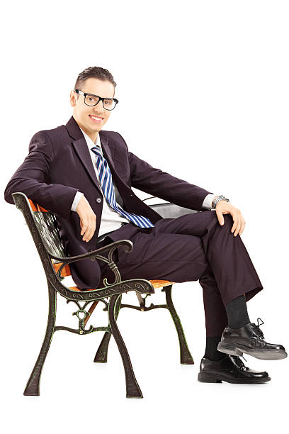 istock Smiling young man in suit sitting on a bench 186050162