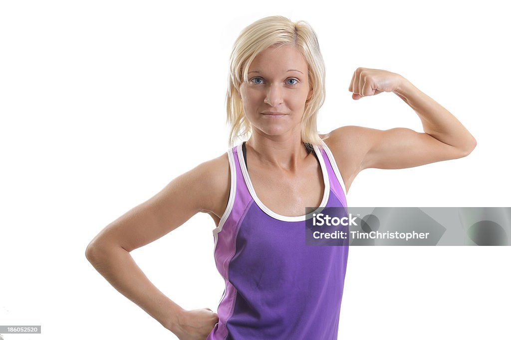 Beautiful Blue Eyed Flexing Blond An attractive blond flexes her left bicep, showing off her physically fit torso. Active Lifestyle Stock Photo