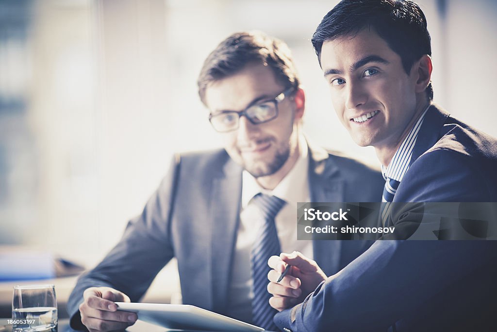 Businessmen at meeting Image of smart young businessmen looking at camera at meeting Adult Stock Photo
