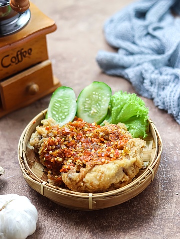 Ayam geprek, or Smashed chicken, is a popular street food in Indonesia. Made from Crispy Chicken Smashed in Sambal Bawang (Chilli Garlic Sauce) with a spicy level. Served with rice and vegetables