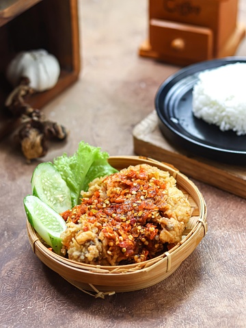 Ayam geprek, or Smashed chicken, is a popular street food in Indonesia. Made from Crispy Chicken Smashed in Sambal Bawang (Chilli Garlic Sauce) with a spicy level. Served with rice and vegetables