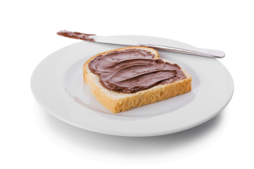 Hazelnut and chocolate spread over a slice of bread