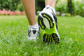 Green heels of a woman's sneaker as she ran on grass