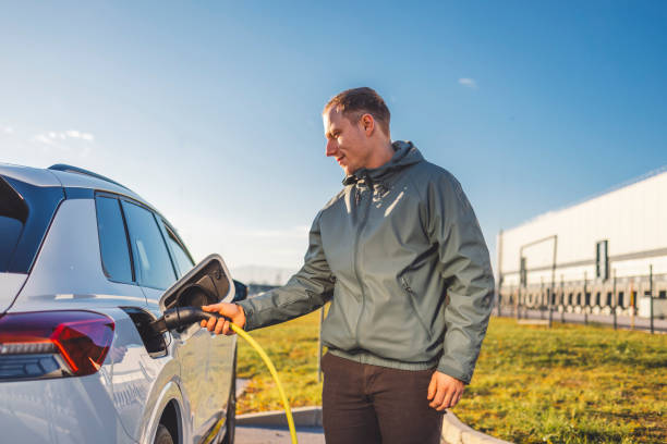 istock Young man charging car at electric vehicle charging station 1860570849