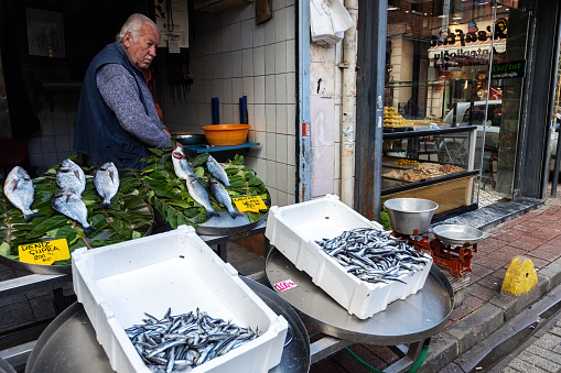 Old Turkish man selling fish on the market in Balat area Istanbul Turkey