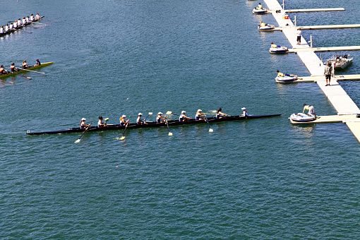 Women Crew Rowing Team In Boat On Lake Near Dock Practicing Northern California