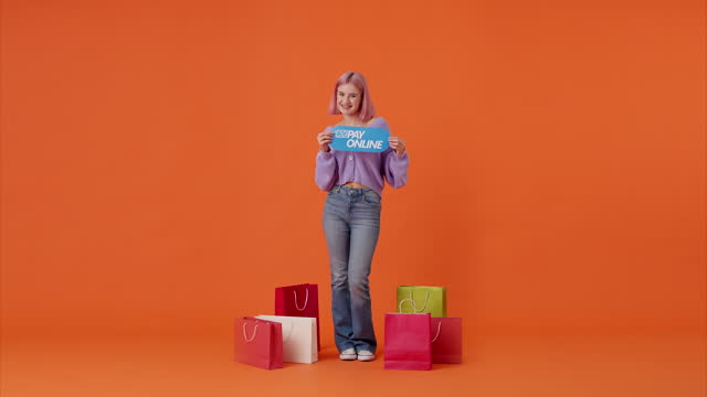 Female showing banner while standing near bags in studio