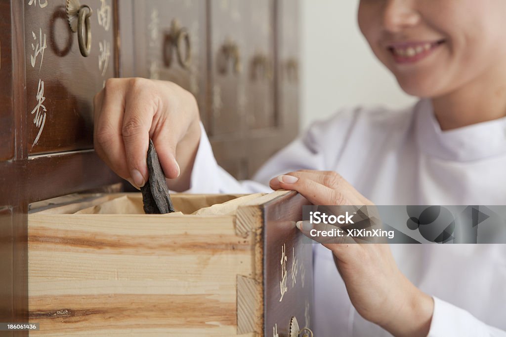 Doctor Taking Herb Used for Traditional Chinese Medicine Doctor Taking Herb Used for Traditional Chinese Medicine Out of a Drawer Accessibility Stock Photo