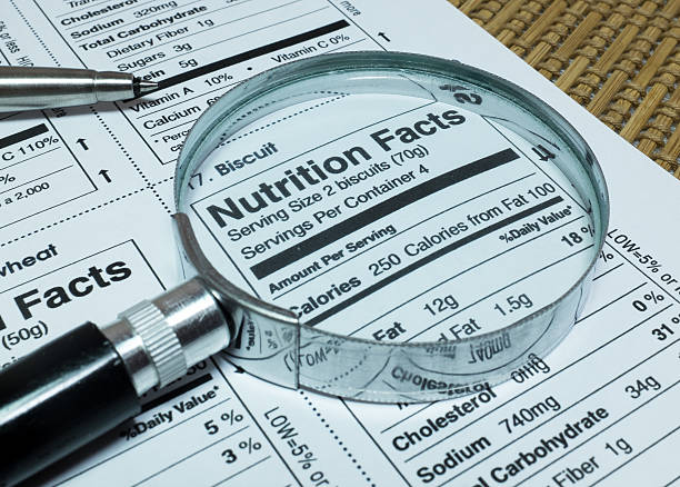 loupe mettant en valeur des aliments faits nutrition - information nutritionnelle photos et images de collection