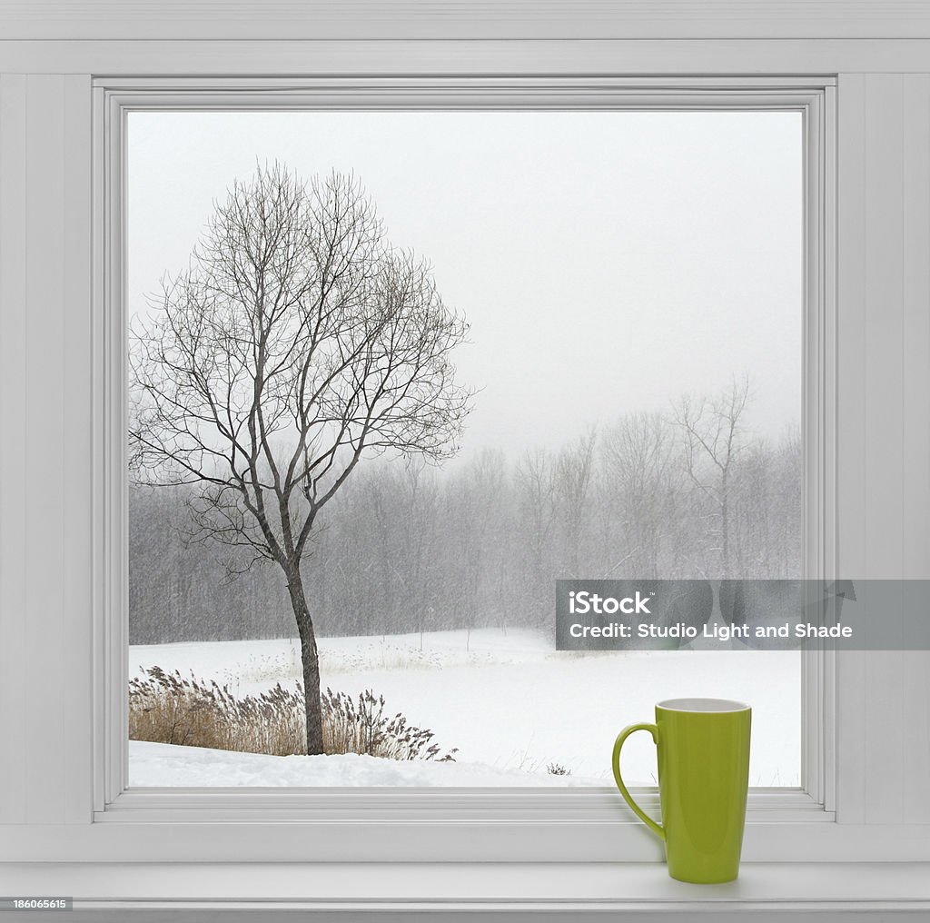 Winter landscape seen through the window and green cup Green teacup on a windowsill, with winter landscape seen through the window. Black And White Stock Photo