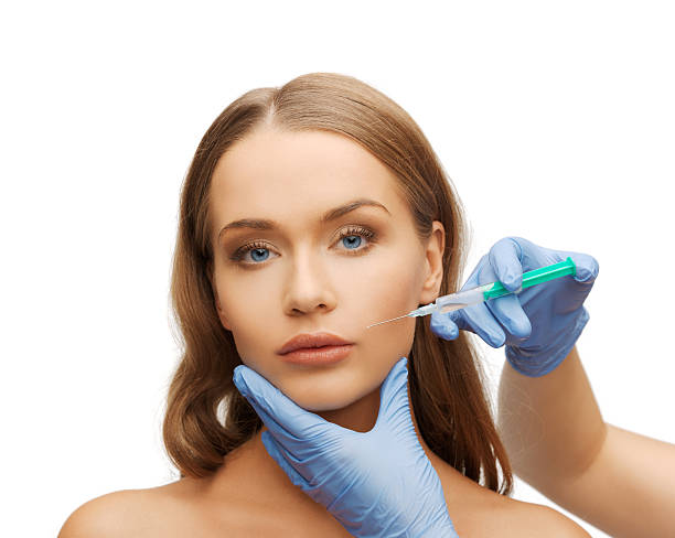 istock woman face and beautician hands with syringe 186065943