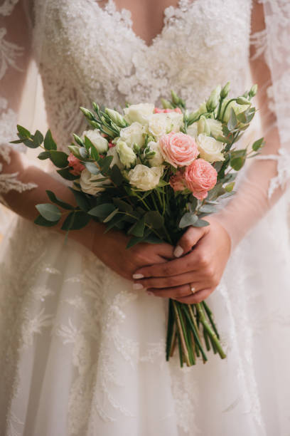 istock Wedding bouquet in bride's hands. Bride's bouquet with roses. Close up 1860661407