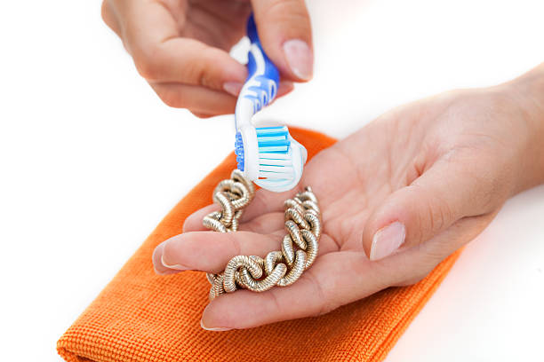 cleaning golden bracelet with a toothpaste - hand gold jewels bildbanksfoton och bilder