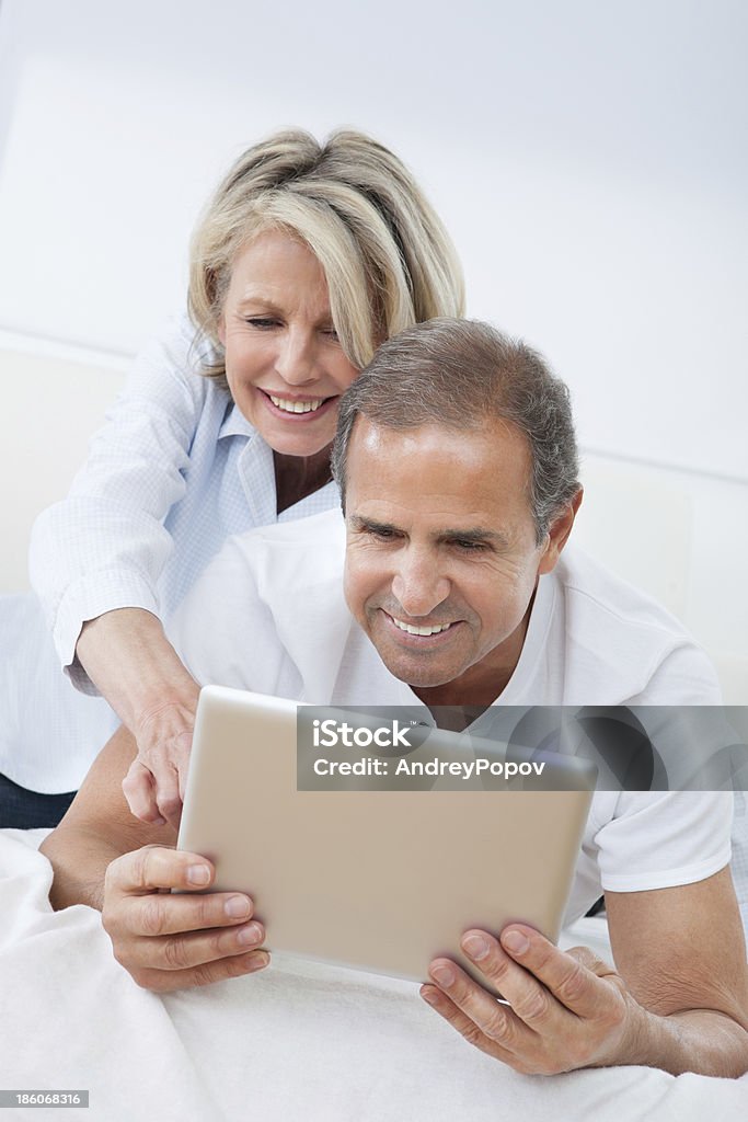 Happy Mature Couple Looking At Digital Tablet Happy Mature Man Using Digital Tablet Woman Looking From Behind Digital Tablet Stock Photo