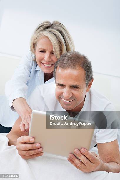 Happy Mature Couple Looking At Digital Tablet Stock Photo - Download Image Now - Digital Tablet, Enjoyment, Happiness