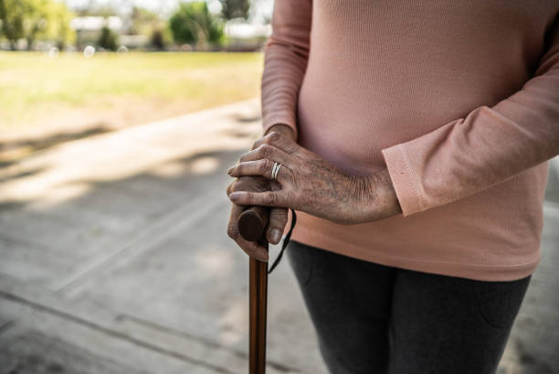 istock Senior woman walking with cane at public park 1860683791