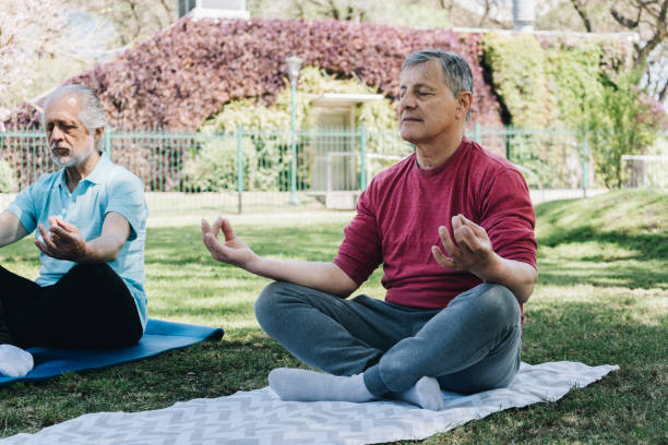 istock Senior man meditating in lotus position at public park 1860688430