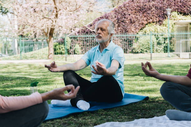 istock Senior man meditating in lotus position at public park 1860688435