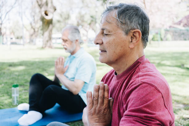 istock Senior man meditating in prayer pose at public park 1860689970