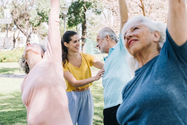 istock Yoga instructor helping senior man during outdoor yoga class 1860693561