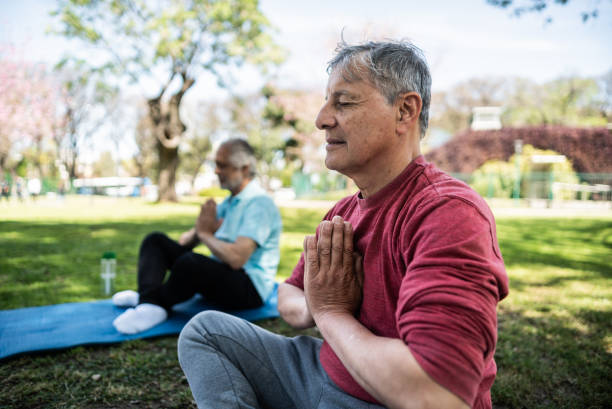 istock Senior man meditating in prayer pose at public park 1860696150