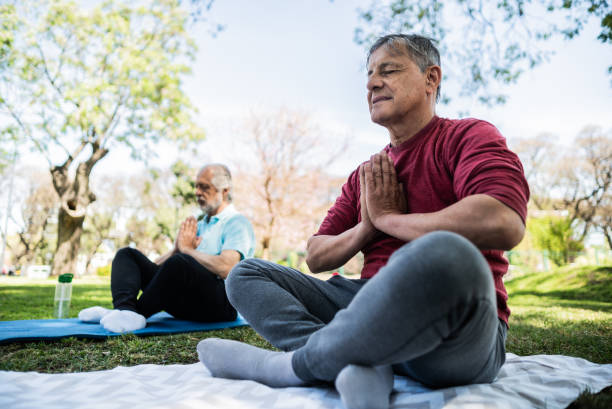 istock Senior man meditating in prayer pose at public park 1860696152